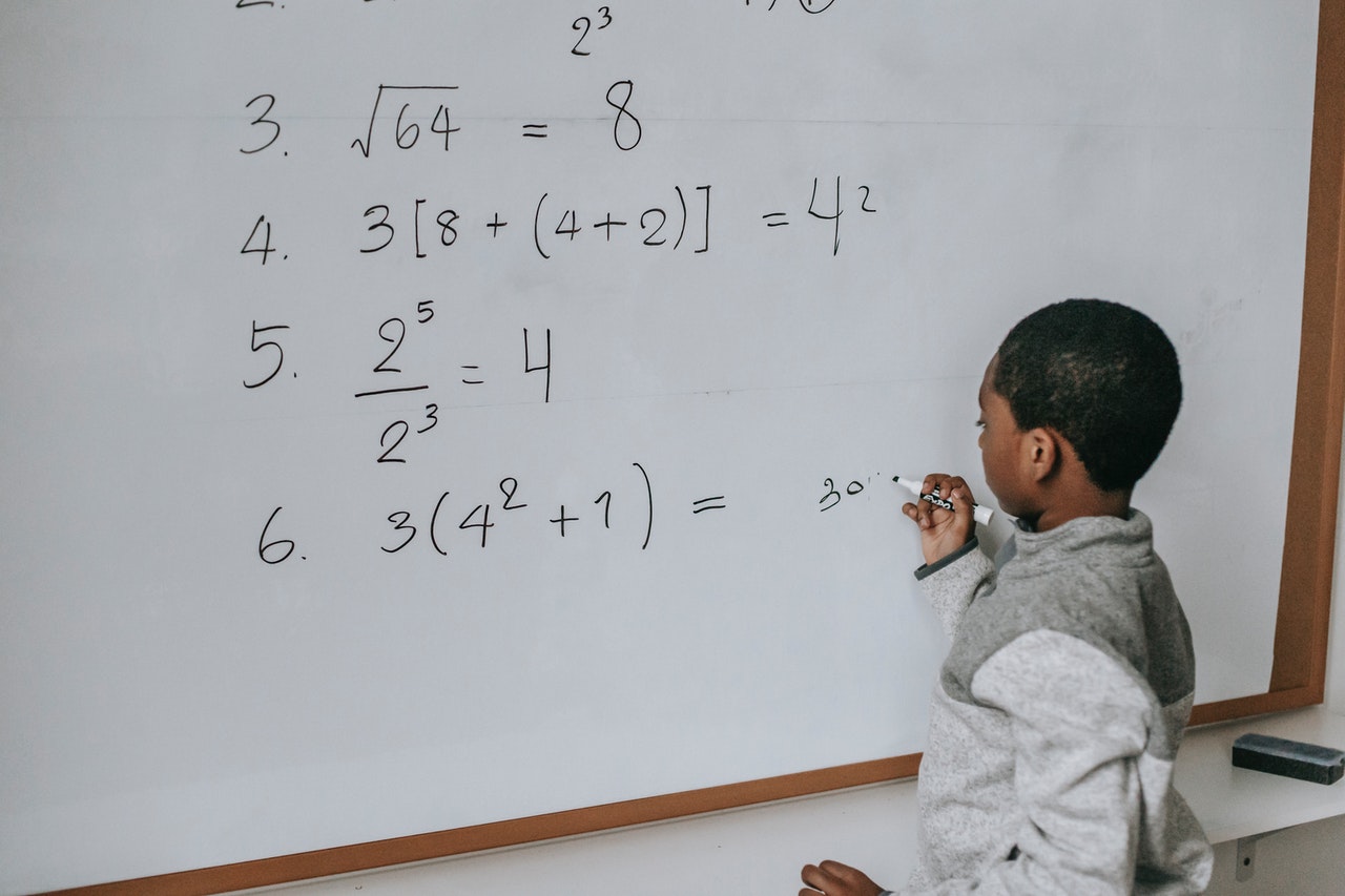African american boy drawing on whiteboard